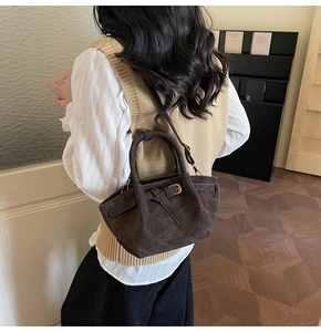 Detailansicht der dunkelbraunen Wildleder-Eimertasche mit Steppmuster und Riemen