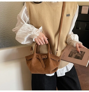 Detailansicht der braunen gesteppten Eimertasche mit Zierschnalle und goldenen Beschlägen