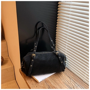 Detailed macro view of black matte leather Boston bag featuring elegant gold hardware buckles