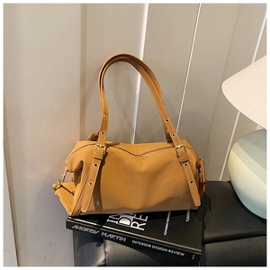 Detail of retro mustard yellow leather tote bag with metallic eyelets and buckle accents