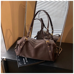 Detailed view of dark brown retro bowling bag with matte leather and gold eyelet straps