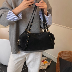 Detail of black Boston bag with golden eyelets and adjustable buckles on the strap