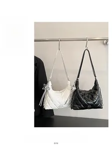 Detail of quilted rhombic texture on black and white tote bags with metal chain straps