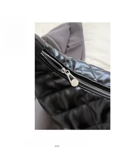 Detailed macro view of the smooth silver zipper and quilted diamond pattern on black bag