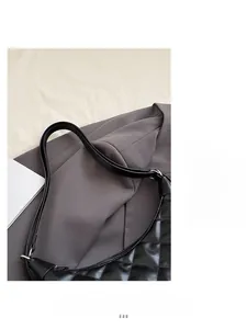 Detail of black quilted leather shoulder bag with silver buckle and diamond stitch texture