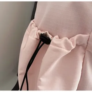 Close-up of pink ripstop fabric with drawstring closure and durable plastic cord lock