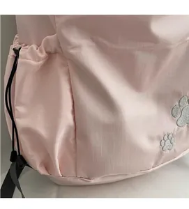Detail of light pink backpack featuring ripstop grid fabric and side drawstring pocket