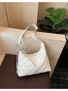 Detail of white quilted leather bag with silver star charm and metallic chain strap