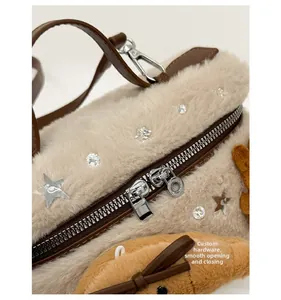 Détail de la fermeture éclair en argent et du tissu en peluche douce du sac beige