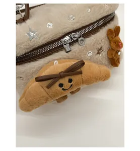 Gros plan d'un sac en peluche avec pendentif croissant et breloque lapin brun