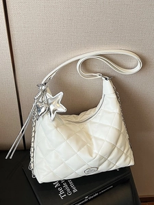Quilted white hobo tote bag with silver chain and star charm on a beige textured backdrop