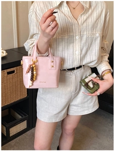 Pink faux leather bucket bag with retro wooden beads and elegant gold rivet details