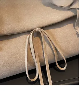 Detail shot of beige suede tote bag showing soft texture and thin drawstring tie design