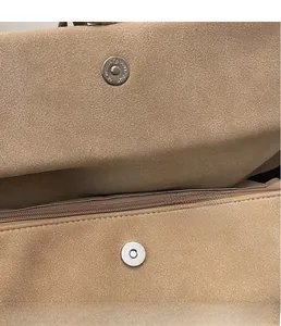 Close-up of suede texture featuring silver magnetic snap button and interior zipper pocket