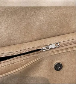 Detail of suede tote bag featuring polished silver zipper and magnetic snap closure