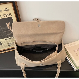 Detail view of large beige tote bag showing black fabric lining and interior zipper pocket