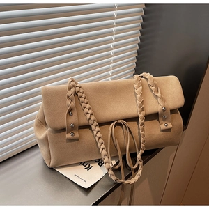 Detail of woven handle and khaki suede texture on a large minimalist tote bag