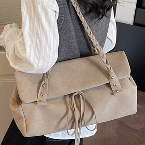 Beige large capacity tote bag with woven strap and suede texture worn by a model