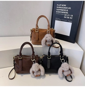 Detailed texture of woven leather handbags in brown and black with gold ring hardware