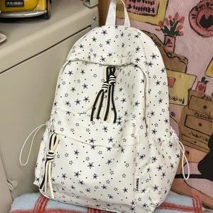 Détails du sac à dos en toile blanche avec imprimé étoiles noires et cordons rayés