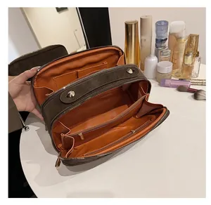 Detailansicht der dunkelbraunen Kulturtasche mit zwei Hauptfächern und orangefarbenem Futter