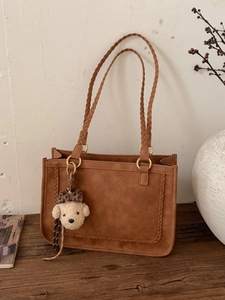 Bolso tote marrón vintage con bordes trenzados y un lindo colgante de peluche de animal