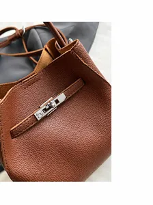 Dettaglio borsa a secchiello in pelle marrone con chiusura girevole in metallo