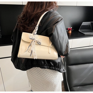 Elegante bolso de hombro en cuero brillante beige con detalle de cinta decorativa