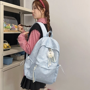 Détail du sac à dos bleu clair à imprimé étoiles avec un joli charme en peluche