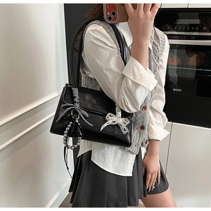 Detalle del bolso de cuero PU negro con lazos de seda, corazón de encaje y cuentas