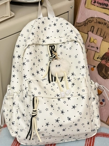 Sac à dos en toile blanche avec imprimés étoiles noires et pendentif monstre en peluche