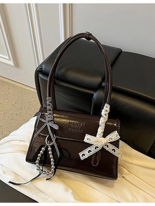 Bolso baguette de charol marrón oscuro con cinta de rayas y lazos de encaje blanco