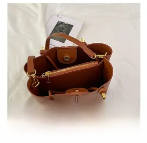 Innenansicht der braunen Leder-Beuteltasche mit Reißverschlussfach und goldfarbenen Beschlägen