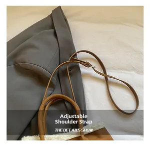 Détail de la bandoulière réglable en cuir marron et de la peluche sur le sac