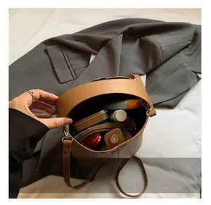 Top-down macro view of brown leather bucket bag interior showing capacity and magnetic clasp