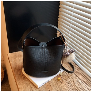 Detail of black litchi texture bucket bag with leopard print and faux fur keychain