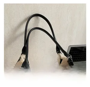 Detail of plush off-white tote bag showing leather strap and silver metal ring hardware