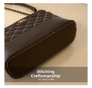 Nahaufnahme der Kontrastnähte einer gesteppten Ledertasche mit Metallkettenriemen