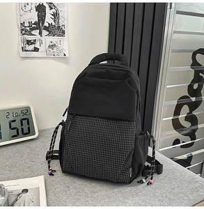 Detail of a black backpack featuring plaid stitching and colorful beads on side drawstrings