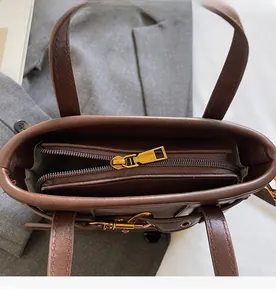 Dettaglio dello scomparto interno con cerniera dorata su borsa a secchiello in pelle marrone