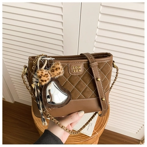 Detail der Vintage-Beuteltasche in Braun mit mattem Wildleder und goldener Logoplakette