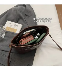 Interior view of brown quilted bucket bag showing large capacity for phone and wallet
