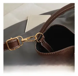 Nahaufnahme der braunen Vintage-Mattledertasche mit goldenem Haken und feiner Steppnaht