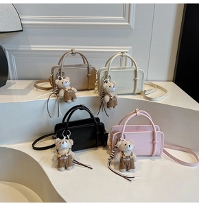 Quatre sacs bandoulière en similicuir chic beige, blanc, noir et rose avec oursons peluche