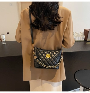 Detailed back view of a black quilted leather crossbody bag with golden chain strap