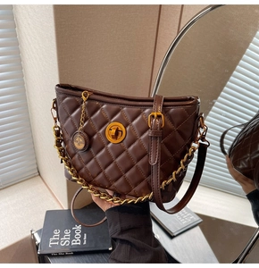 Detailed view of brown quilted hobo bag with gold metal twist lock and chain strap