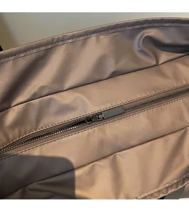 Détail de la fermeture éclair métallique et du nylon sur le sac fourre-tout