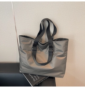Détail du sac cabas en nylon gris avec sangle noire et anneau métallique argenté