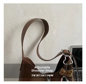 Détail du sac bandoulière marron en cuir avec sangle réglable et nœud léopard