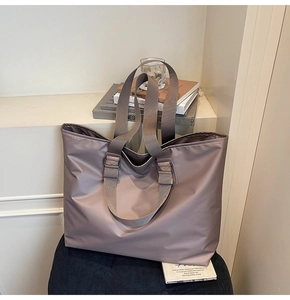 Détail du sac fourre-tout en nylon violet gris sur une chaise avec des livres de style